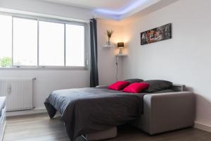una camera con un letto con due cuscini rossi di SWEETHOME DIJON - ALBERT 1er a Digione
