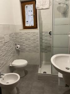 a bathroom with a toilet and a shower and a clock at Casa Donna di Cuori in Fiumicino