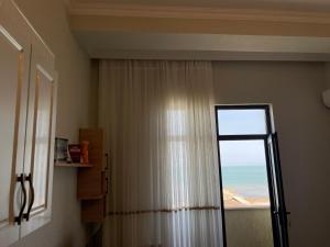 a room with a window with a view of the ocean at Caspian Pearl Residence in Sumqayyt