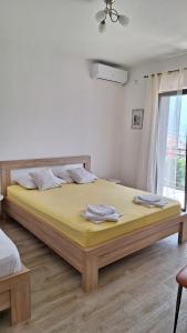 a bedroom with a large bed with yellow sheets at Bonaca Apartments in Kotor