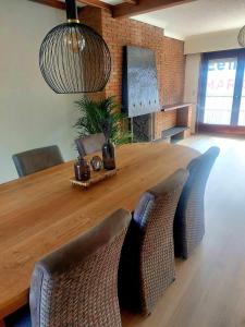 een eettafel met stoelen en een grote houten tafel bij Huys 34, uw thuis weg van huis in Maldegem