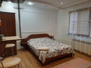 1 dormitorio con 1 cama, mesa y sillas en Комфортный en Karpaty