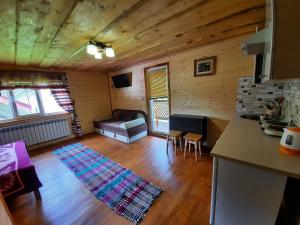 een woonkamer met een bank en een houten vloer bij Садиба У Ані номер 4 in Synevyrsʼka Polyana