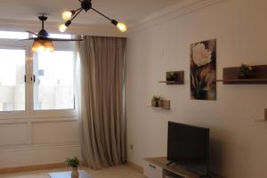 a living room with a television and a window at Giza - Pyramids/Museum Apartment in Cairo