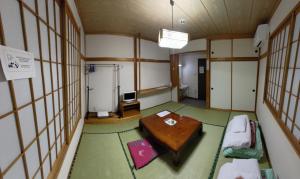a room with a table in a room with windows at Sunshine Kyohei in Nozawa Onsen