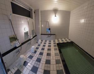 a bathroom with a swimming pool and a tiled floor at Sunshine Kyohei in Nozawa Onsen