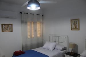 a bedroom with a bed and a lamp and a window at Giza - Pyramids/Museum Apartment in Cairo