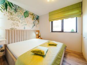 a bedroom with a bed with two yellow pillows on it at RAINFOREST APARTAMENT in Ghimbav