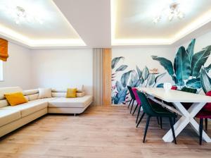 a living room with a couch and a table with chairs at RAINFOREST APARTAMENT in Ghimbav