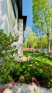 una casa con un giardino fiorito ed erba di Le stanze di Caterina a Cesenatico