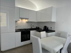 eine Küche mit weißen Schränken sowie einem Tisch und Stühlen in der Unterkunft Apartment Centro Parioli in Rom