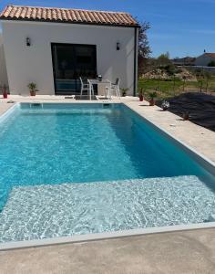 a swimming pool in front of a house at Love room in Gémozac