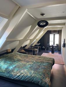 ein Schlafzimmer mit einem großen Bett im Dachgeschoss in der Unterkunft Texels Goud Deluxe Suites in Den Burg