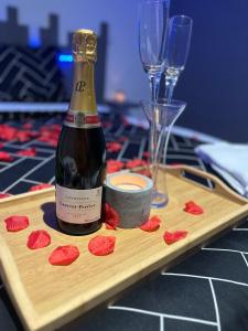 a bottle of wine on a wooden tray with wine glasses at Love room in Gémozac