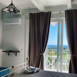 a bedroom with a bed and a large window at L'incanto di Nausicaa in Ascea
