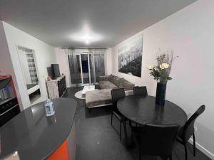 a living room with a table and a couch at Appartement proche Paris, C DG, Disney, Parking. in Aulnay-sous-Bois