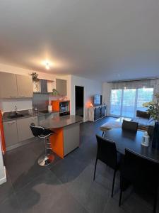 a kitchen and living room with a table and a dining room at Appartement proche Paris, C DG, Disney, Parking. in Aulnay-sous-Bois