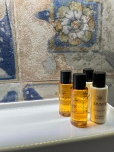tre bottiglie di senape sedute su una vasca da bagno di B&B Centro Storico a Diamante