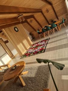 um quarto com uma mesa e cadeiras e um tapete em Casuta Armonia em Moisei