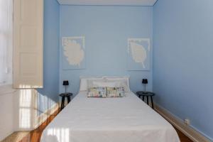 um quarto azul com uma cama com um cobertor branco em 708 Mugnano House Aveleda em Vila do Conde