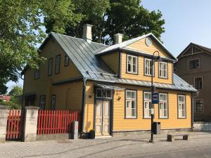 a yellow house with a metal roof at Lossi Apartment in Kuressaare