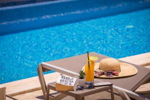 a table with a sandwich and a drink on it next to a pool at Kalkan Saray Suites Hotel in Kalkan