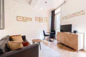 a living room with a couch and a television at Studio standing plein centre Aix in Aix-en-Provence