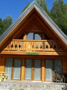 ein Holzhaus mit Balkon darüber in der Unterkunft Casuta Armonia in Moisei