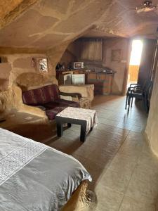 Habitación con cama y sofá en una cueva en המערה הפוריה בפוריה, en Poriyya