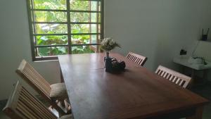 a dining room table with a vase of flowers on it at Osu Lena Habaraduwa in Habaraduwa Central