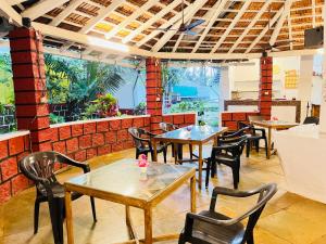a restaurant with tables and chairs and windows at Red Sea Beach Resort in Anjuna