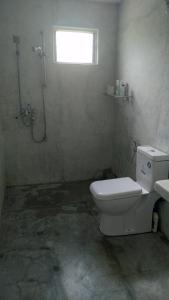 a bathroom with a shower and a toilet and a window at Osu Lena Habaraduwa in Habaraduwa