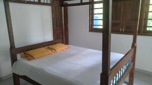 a bedroom with a canopy bed with white sheets at Osu Lena Habaraduwa in Habaraduwa