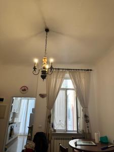 lampadario pendente appeso a un soffitto in una stanza con finestra di Alloggio in centro ben servito a Savona