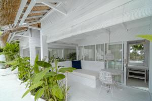 a living room with a white couch and some plants at Gravity Eco Boutique Hotel - Adults Only in Uluwatu