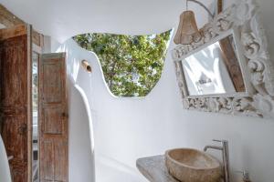 a bathroom with a sink and a mirror at Gravity Eco Boutique Hotel - Adults Only in Uluwatu