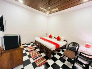 a bedroom with a bed and a tv and a checkered floor at Red Sea Beach Resort in Anjuna