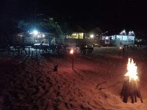 ein Strand in der Nacht mit Feuer im Sand in der Unterkunft Elegant Green Beach Resort in Trincomalee