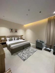 a bedroom with a large bed and a chair at HIGH VIEW HOTEL فندق عالية الاطلالة in Hafr Al-Batin