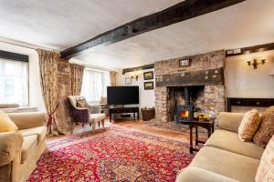a living room with a stone fireplace and a television at The Oval in Dunster