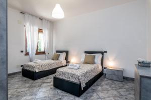 Un dormitorio con dos camas en una habitación. en Villa Estia - nel cuore della Valle D'Itria, en Cisternino