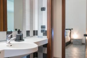 un baño con lavabo y espejo en Villa Estia - nel cuore della Valle D'Itria, en Cisternino 39 fotos más