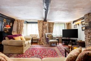 a living room with a couch and a flat screen tv at The Oval in Dunster +41 photos
