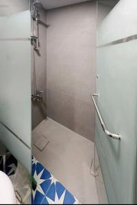 una doccia con porta in vetro in bagno di Duplex guest house in Batroun a Batroûn