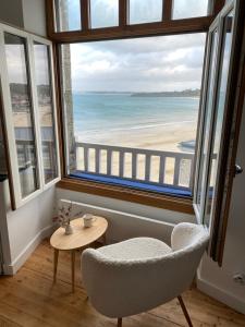 Habitación con silla y vistas a la playa en Le Petit Saint Cast - Cocon vue Mer, en Saint-Cast-le-Guildo