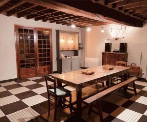 uma cozinha com uma grande mesa de madeira e cadeiras em Longère normande, parc, piscine. em Montchevrel