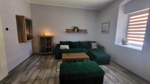 - un salon avec un canapé vert et une table dans l'établissement Seoska kuća Totđerđ, 