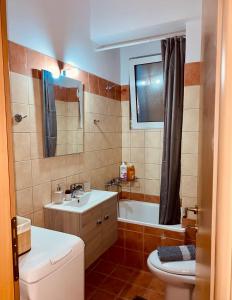 a bathroom with a sink and a toilet and a tub at 22 Apartment with private parking in Larisa