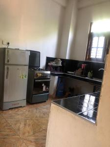 a kitchen with a refrigerator and a stove in it at Calm Palace in Weligama