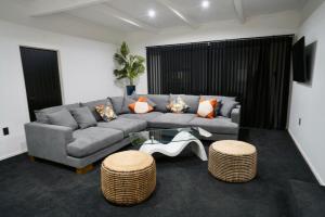 a living room with a couch and two stools at A Dreamed Home Away From Home in Rotorua